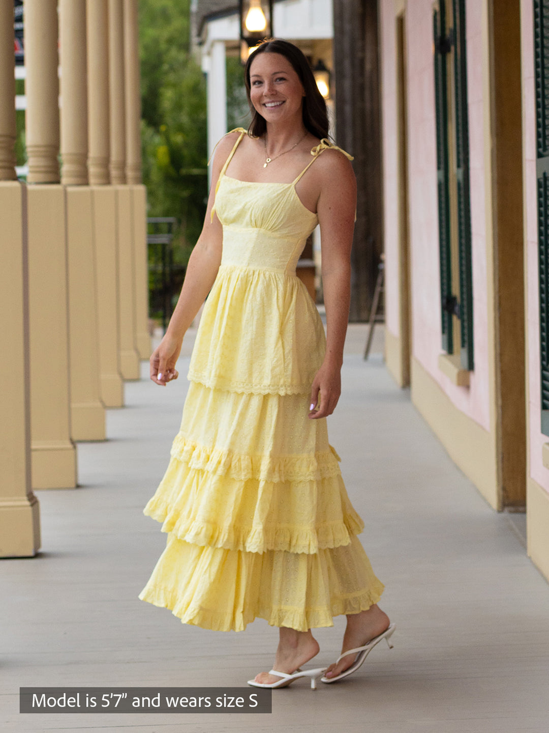 Woman wearing butter yellow Florence maxi dress with shiffli embroidery, square neckline, and tiered design