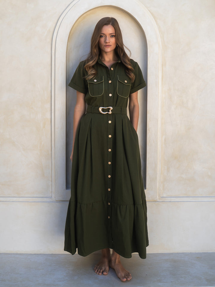 Woman wearing a green dress standing in front of an archway.