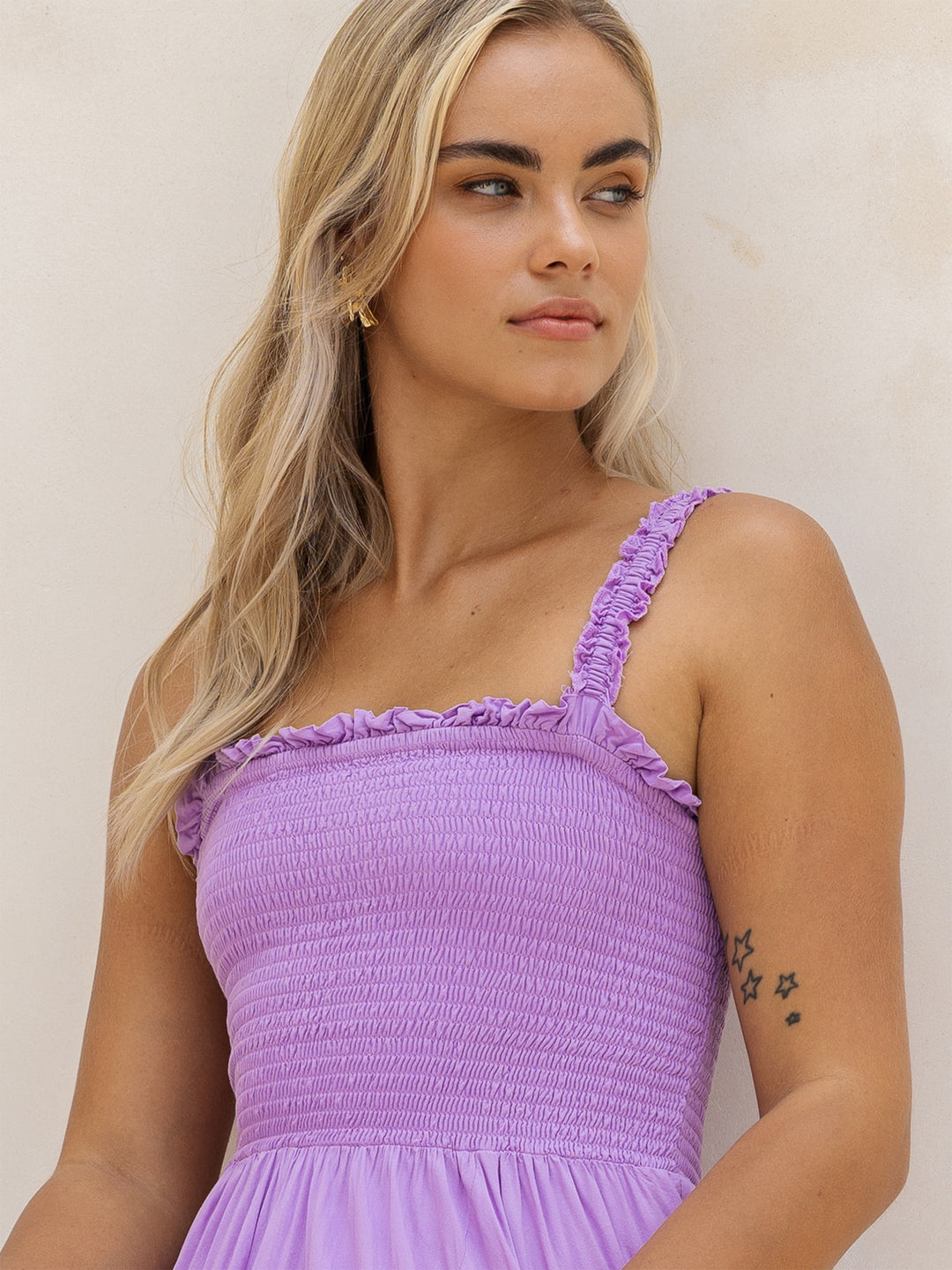 Woman wearing a purple dress against a plain background