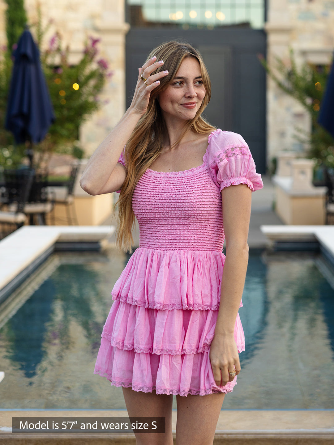 Boho-chic pink mini dress with smocked bodice, puff sleeves and tiered ruffle skirt