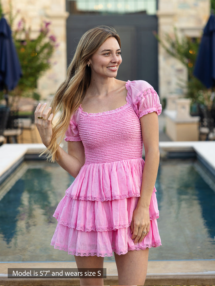 Boho-chic pink mini dress with smocked bodice, puff sleeves and tiered ruffle skirt