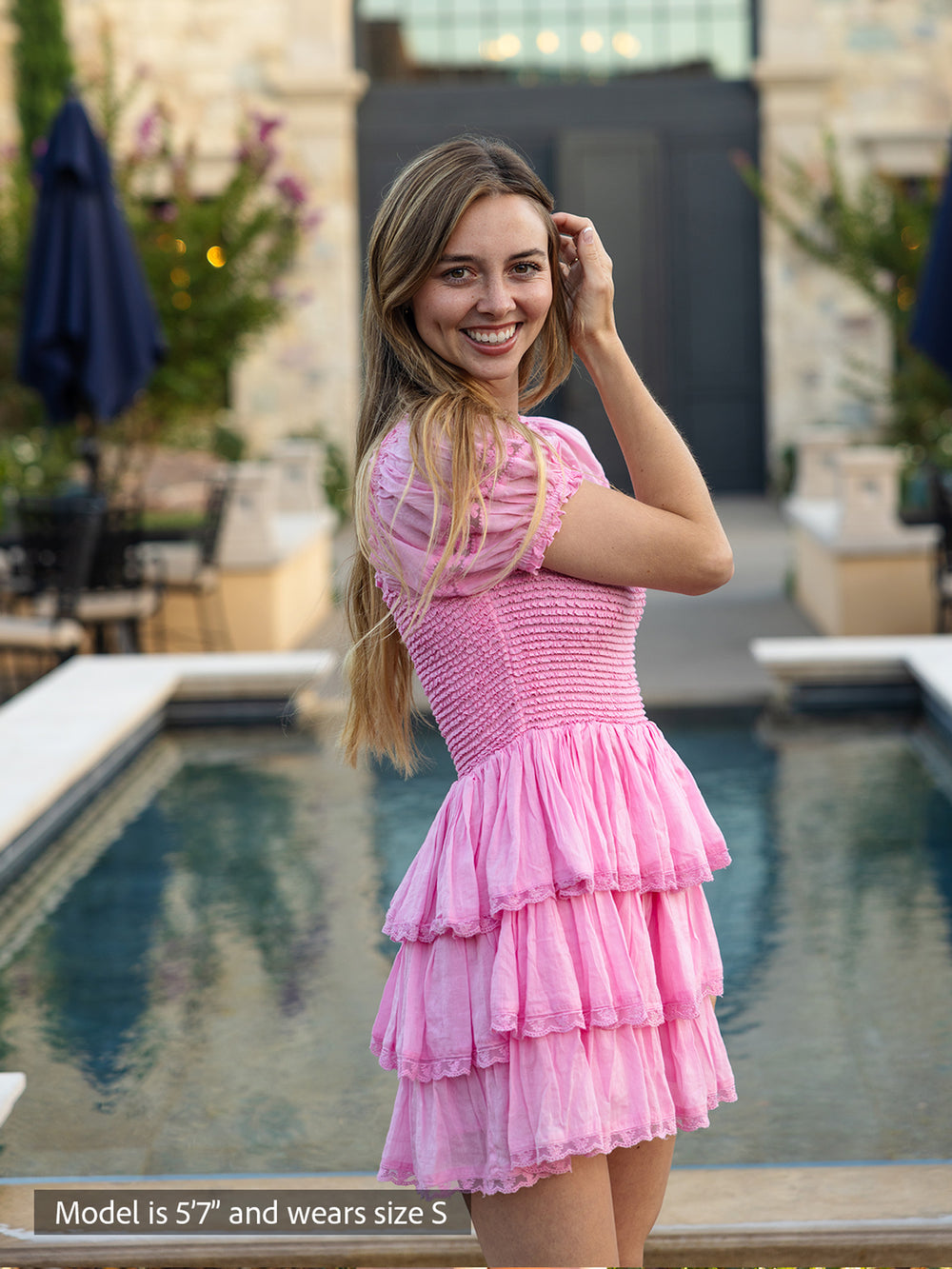 Boho-chic pink mini dress with smocked bodice, puff sleeves and tiered ruffle skirt