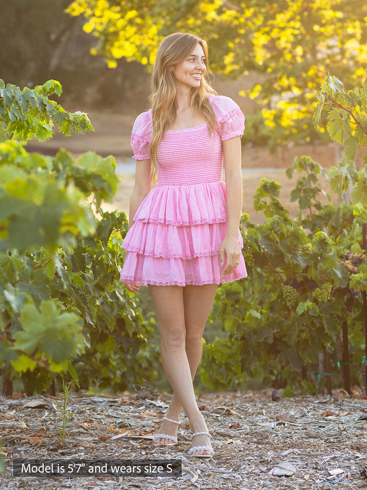 Boho-chic pink mini dress with smocked bodice, puff sleeves and tiered ruffle skirt