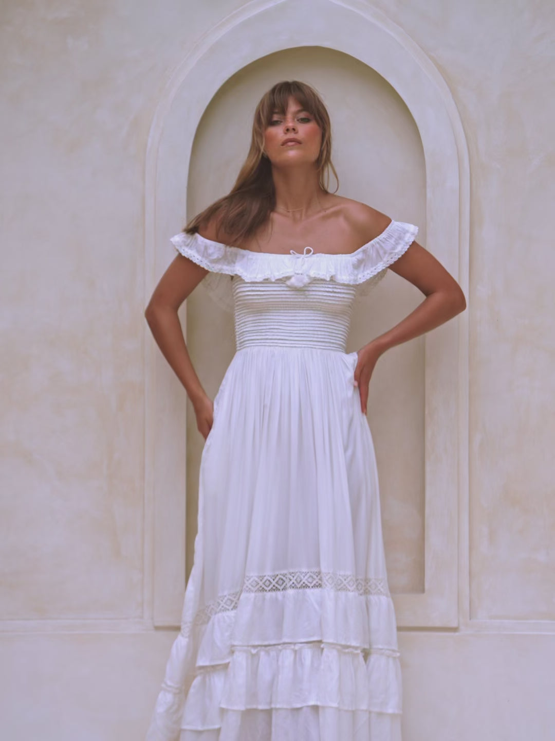 Woman wearing a flowy white off-shoulder dress