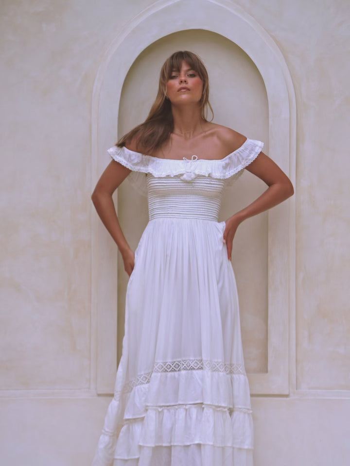 Woman wearing a flowy white off-shoulder dress
