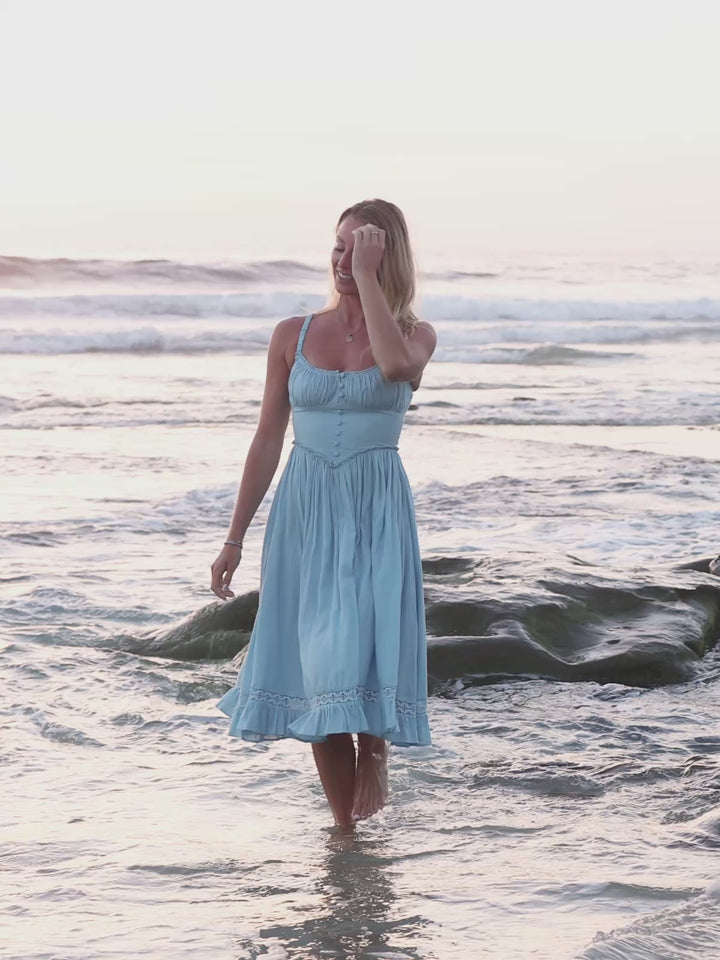 light blue midi dress with parially smocked bodice, V-cut waistline, lace details and side pockets